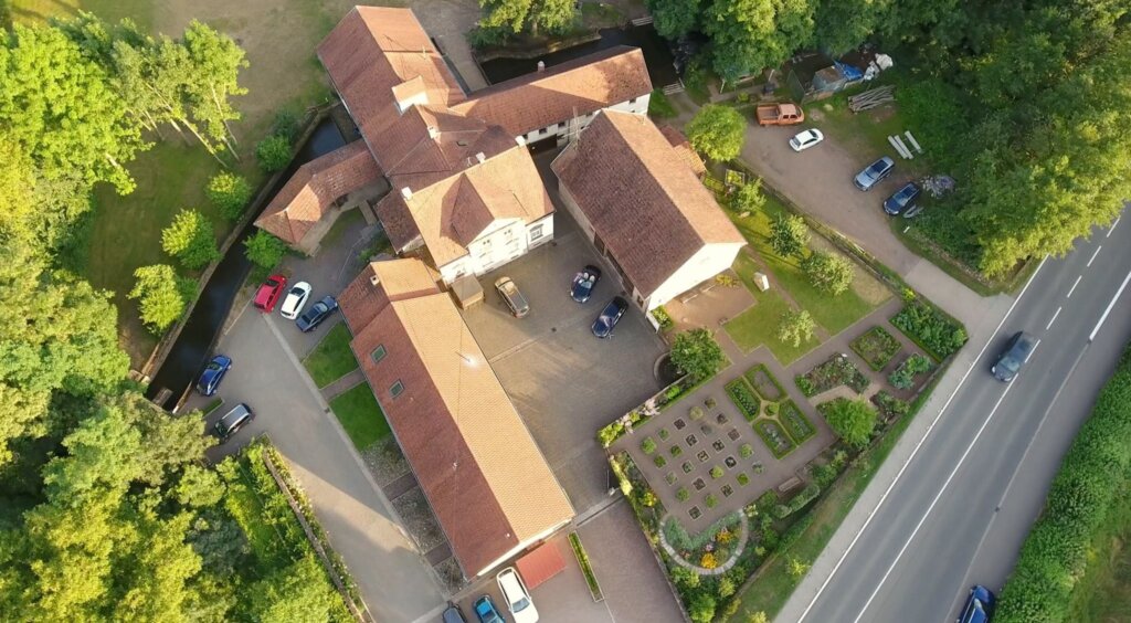 Luftaufnahme der Bettinger Mühle in Schmelz mit Mühlenkanal und Garten